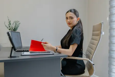 A woman working at a desk with a laptop