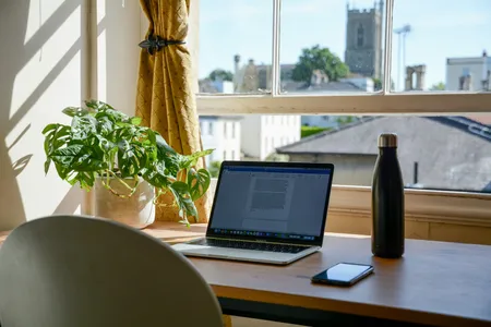 A laptop on a wooden desk in a home workspace