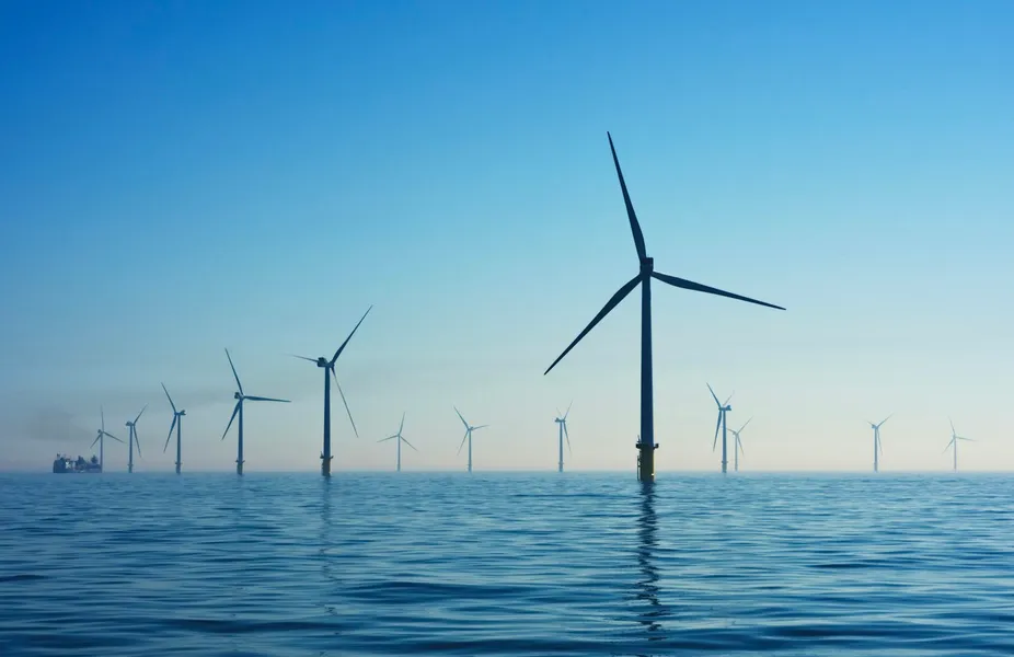 A white wind turbine against the sky